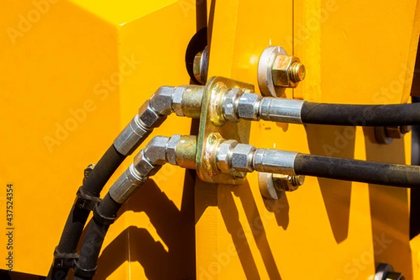 Fototapeta Hydraulic piston system for bulldozers, tractors, excavators, chrome plated cylinder shaft of yellow machine, construction heavy industry detail