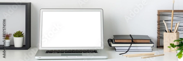 Fototapeta Home office. Desk with an open laptop against a white wall. Mockup. Copy space. Books on the desk. Banner