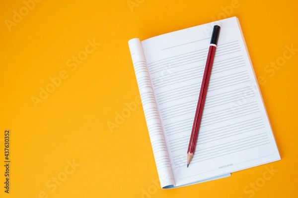 Fototapeta music notebook and pencil with empty background