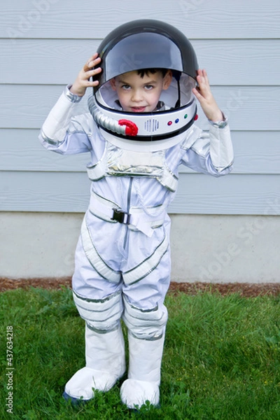 Fototapeta Boy child playing as an astronaut with spacesuit in yard