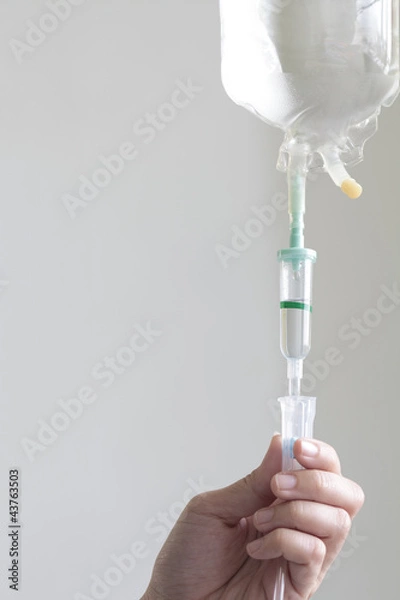 Fototapeta Nurse's hand adjust an IV drip