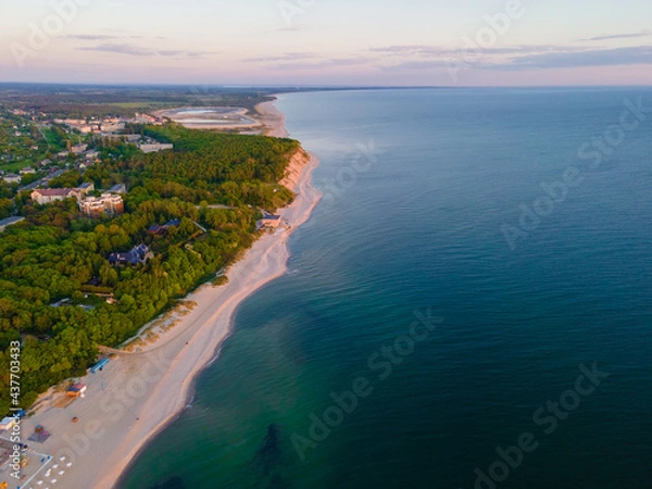 Fototapeta Aerial sunset view of sandy beach, sea and forest on Baltic sea in Yantarny, Kaliningrad region, Russia. top view. shot from drone