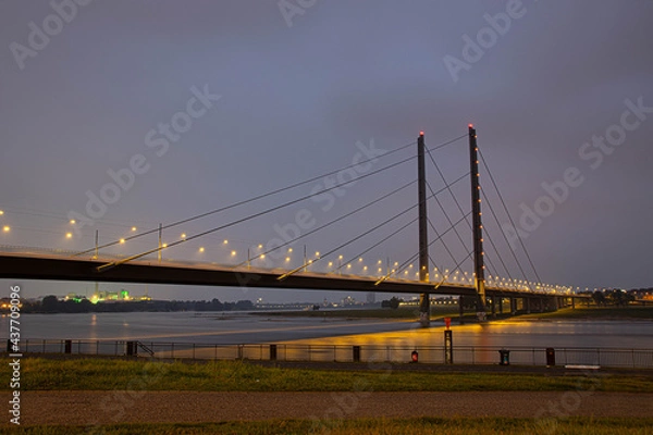 Fototapeta Die Rheinbrücke, die Düsseldorf mit Neuss verbindet. Nachts an der düsseldorfer Rheinpromenade