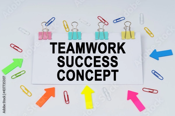 Fototapeta On the table there are paper clips and directional arrows, a sign that says - TEAMWORK SUCCESS CONCEPT