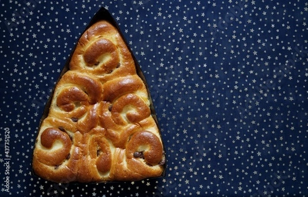 Obraz Delicious New Year's pie with raisins on a blue background. Close-up 