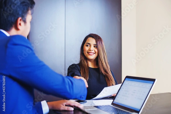 Obraz Welcome onboard concept. Indian man and woman shake hands in office