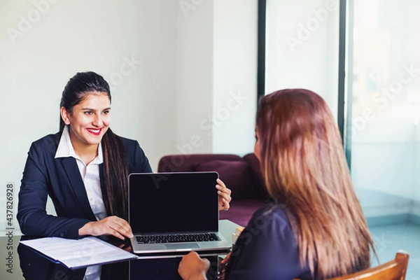Obraz Indian woman in formal suit showing laptop with empty screen to the client