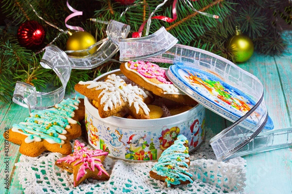 Fototapeta A box of holiday cookies on the table next to the branches of the Christmas tree, Christmas toys
