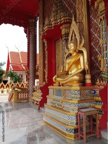 Obraz statue of a sitting golden buddha in a temple in thailand
