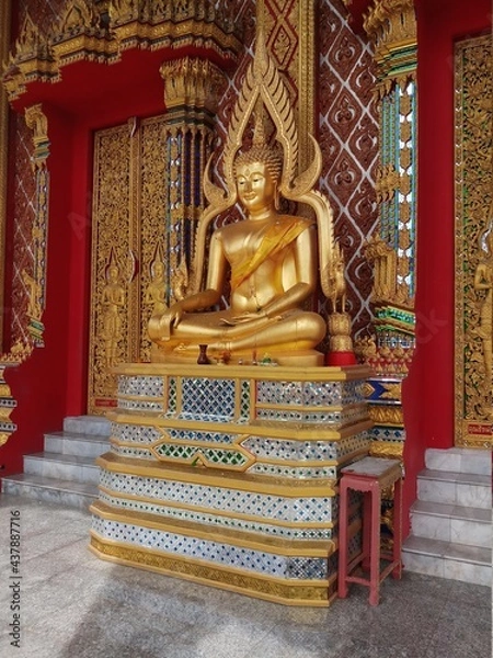 Obraz statue of a sitting golden buddha in a temple in thailand