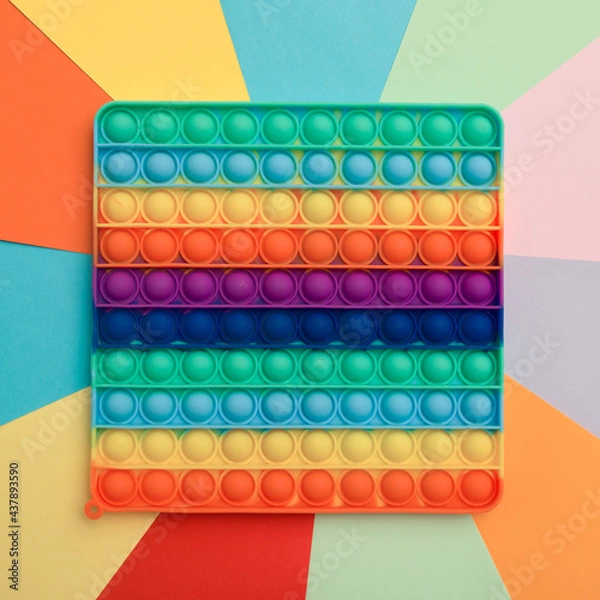 Fototapeta Close up colorful silicone children toy antistress pop it top view on colorful background 