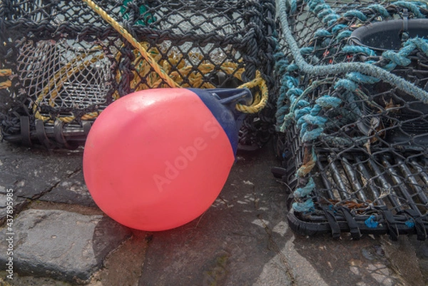 Fototapeta Close up image of a red buoy surrounded by lobster pots 