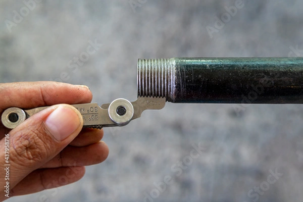 Fototapeta Measurement the pipe threads with thread pitch gauge or screw pitch gauge.