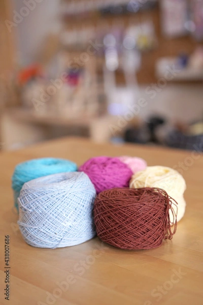 Fototapeta Crochet thread in group as many colors in studio of handicraft school as background. Needles craft on table for hand made hobby.Crochet yarn bag with cotton yarn.