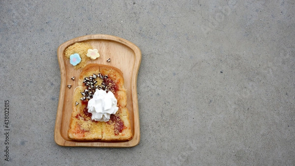 Fototapeta bread with strawberry topping and whipping cream serving with marshmallow on wooden plate