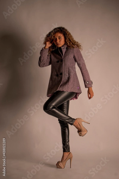 Fototapeta vertical portrait of a curly model wearing a jacket, black pants and heels