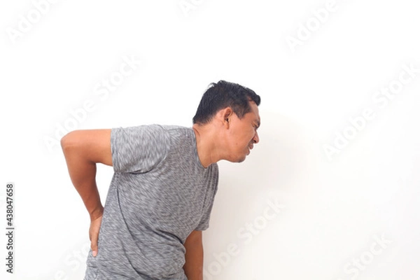 Fototapeta Asian man suffering from backache for having made an effort on isolated background.