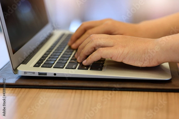 Obraz person typing on a laptop