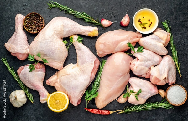 Fototapeta Different parts of chicken for barbecue with breast, legs and wings on stone background