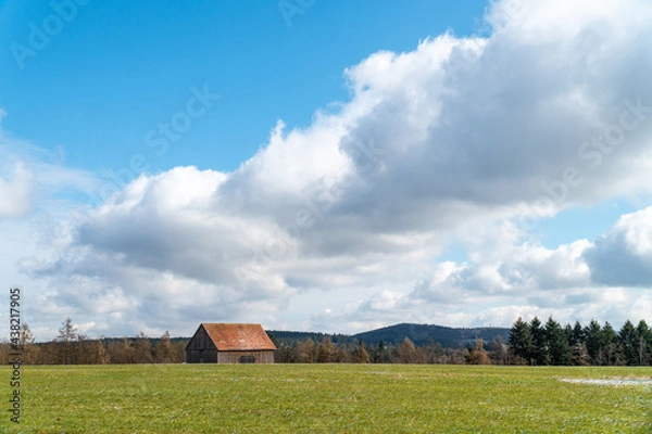 Obraz Wolken, Wiese und Wald mit Scheune