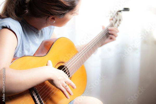 Fototapeta Mujer tocando guitarra española sobre fondo blanco