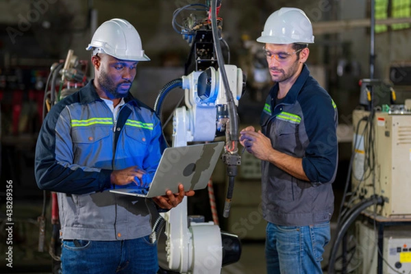 Obraz Two Industry engineers stand and discussion work in the factory workshop.