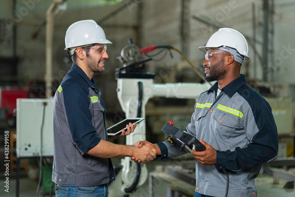 Obraz Two Industry engineers stand and discussion work in the factory workshop.