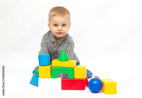 Fototapeta toddler child boy playing toy blocks isolated on white