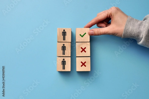 Fototapeta Wooden cubes with drawings of people and a sign of choice . Symbol of potential customers ' choice for business