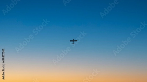 Fototapeta Airplane on the background of a clear blue sky at sunset