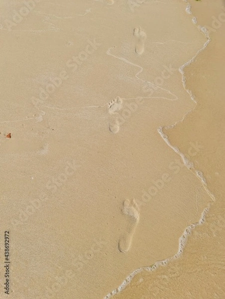 Obraz footprints of a man on the wet sand near the sea on the beach