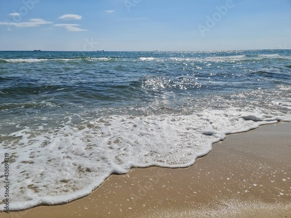 Obraz morning sea, foamy Wave rolls over the Sandy coast, ebb and flow, relaxation, blue sky with clouds, enjoying the calm sea, good weather, vacation, water background