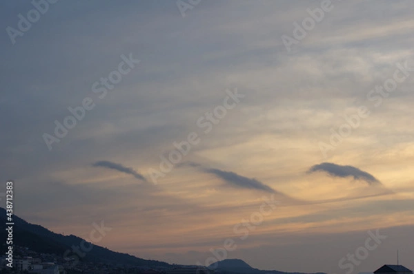 Fototapeta 神戸市東灘区のマンション上層階から明け方の六甲山系。東の空から太陽が昇り空と雲がオレンジ色に染まる。六甲山と甲山の上雲の雲が美しい