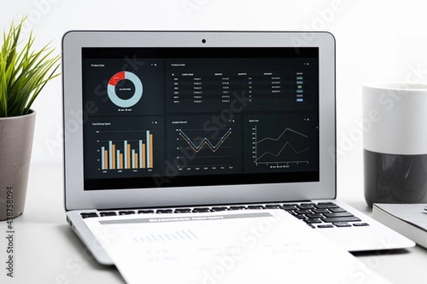 Obraz Laptop with  graph chart report screen on work table. Home office or work space. Strategy analysis financial accounting concept