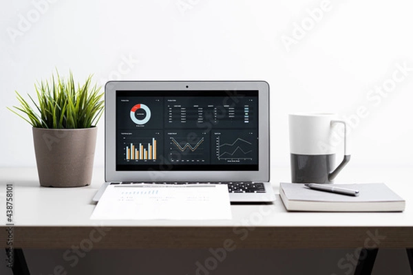 Obraz Laptop with  graph chart report screen on work table. Home office or work space. Strategy analysis financial accounting concept