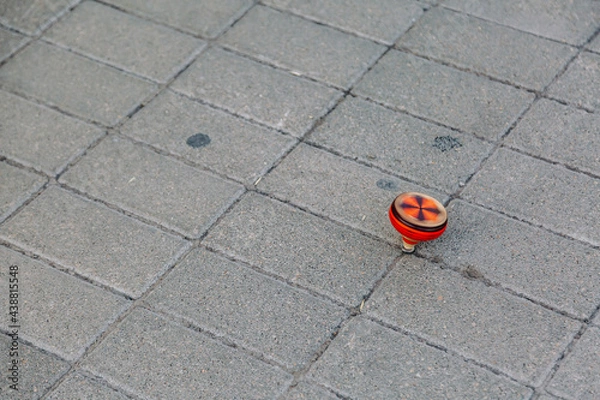 Obraz Spinning toy.  Wooden spinning tops  on the floor.