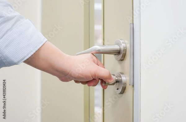 Fototapeta A hand to opening/close door knob, Home Security and Safety Background Concept
