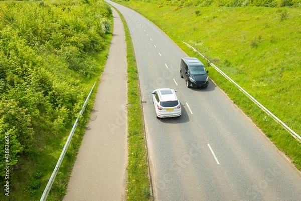 Fototapeta uk motorway road traffic over new build town development in england