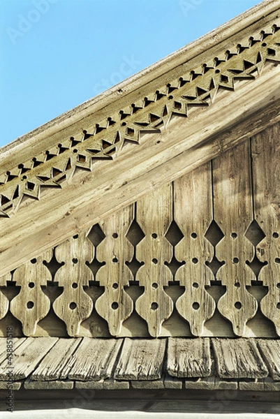 Obraz Part of pediment with decor. Old Russian wooden house in an urban environment.