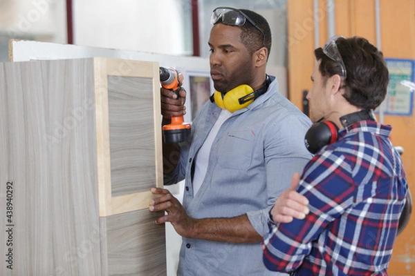 Fototapeta supervisor watching apprentice doing practical carpentry training