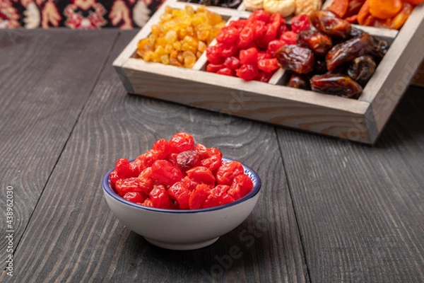 Fototapeta dried cherries in a bowl on a wooden table