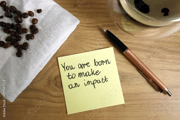 Fototapeta You are born to make an impact text handwritten on sticky note with coffee and pen