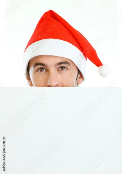 Obraz Male in Santa's hat hiding behind blank billboard