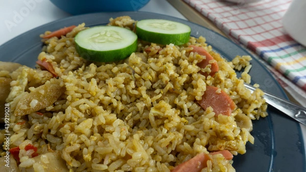 Fototapeta Fried rice served with fresh tomatoes and meatballs in a green tosca ceramic plate and pickles on a white bowl on a white background