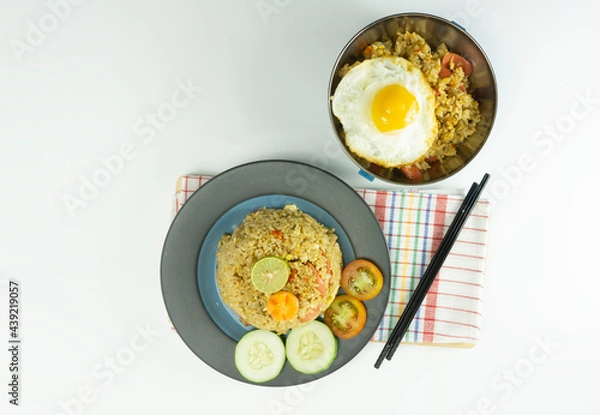 Fototapeta Fried rice served with fresh tomatoes and meatballs in a green tosca ceramic plate and pickles on a white bowl on a white background