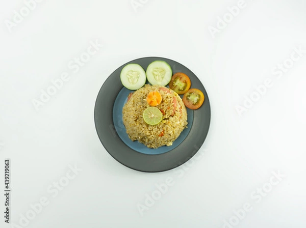 Obraz Fried rice served with fresh tomatoes and meatballs in a green tosca ceramic plate and pickles on a white bowl on a white background