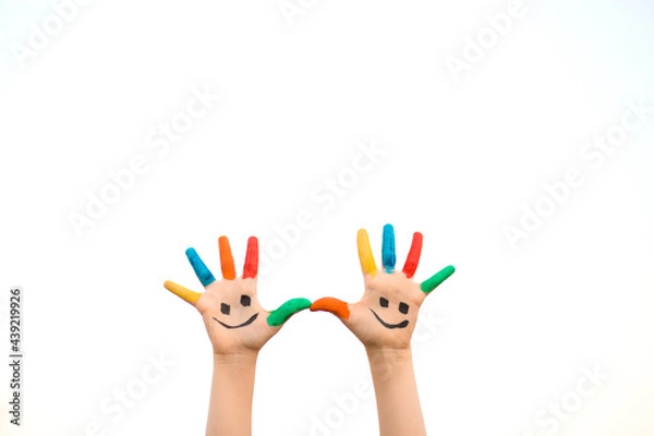 Obraz Banner view of children hands in colorful paint with funny smile face isolated on white background