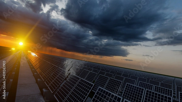 Fototapeta Sunset Over the Solar Panel Field on a Stormy Day 3D Rendering