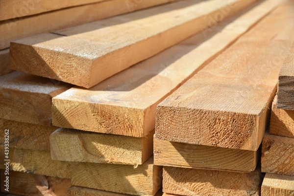 Fototapeta Stacked lumber. Folded wood.Closeup wooden boards.The surface of the end of the board.Lots of planks stacked on top of each other in the warehouse.Lumber for use in construction.
