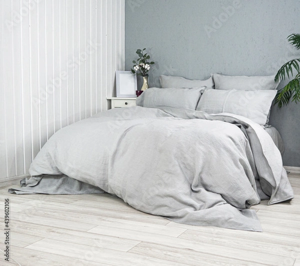 Obraz Sleeping place in the room. Pillows and duvets on the bed with 100% linen bedding. Good home textiles and quality tailoring. Background for advertising sewing production of pillowcases, duvet covers